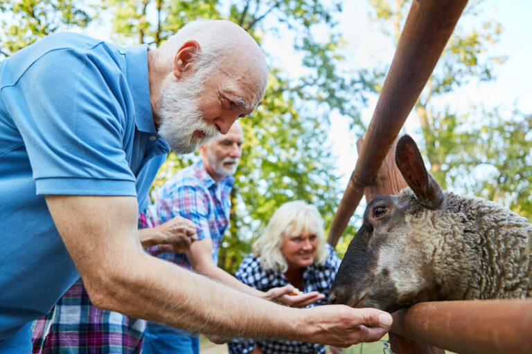 The Gardens at Quail Springs | Senior man at a petting zoo