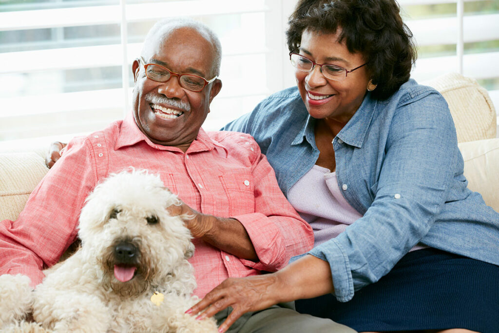 Gardens at Quail Springs | Happy seniors petting a dog