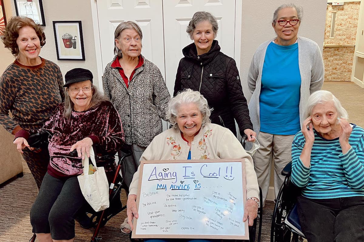 The Gardens | Seniors holding a board showing their advice for getting older